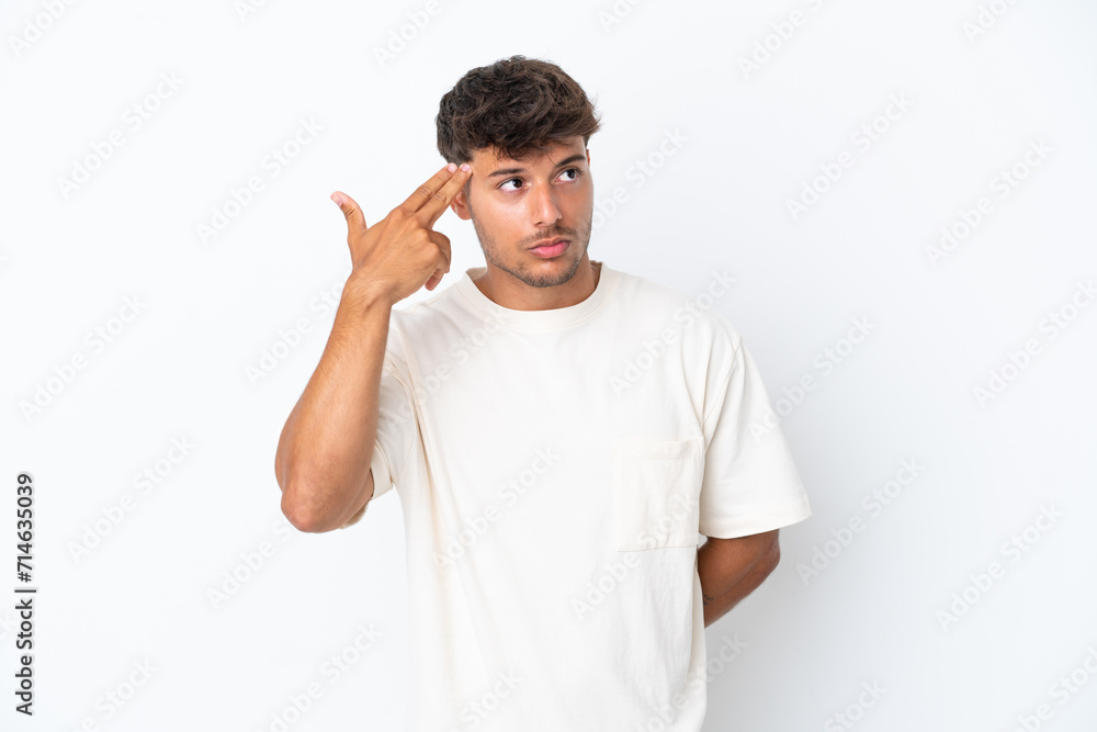 Young caucasian handsome man isolated on white background with problems making suicide gesture Young caucasian handsome man isolated on white background with problems making suicide gesture