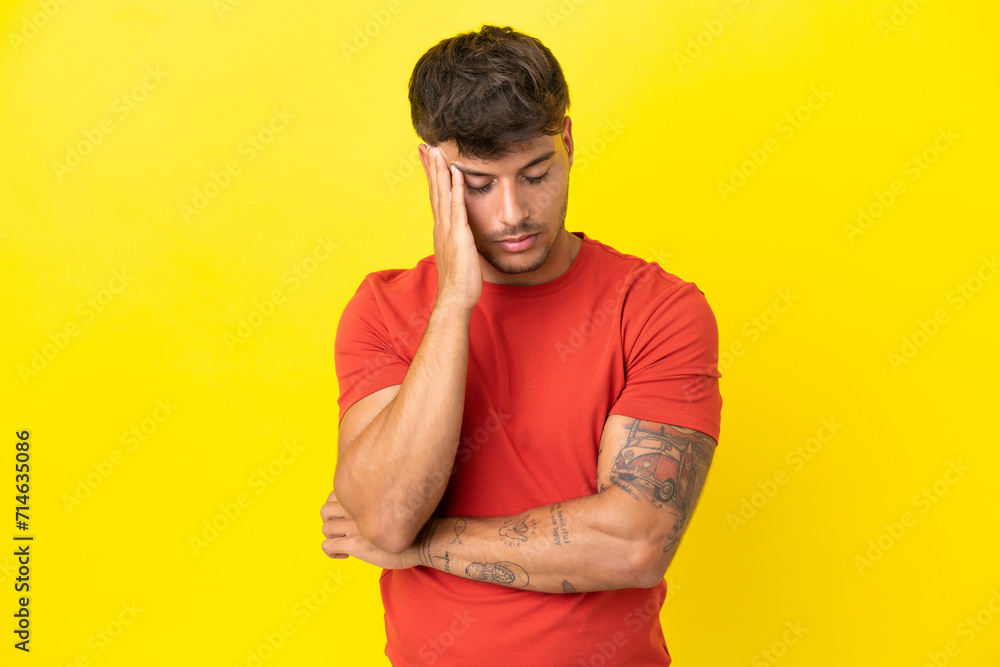 Young caucasian handsome man isolated on yellow background with headache Young caucasian handsome man isolated on yellow background with headache