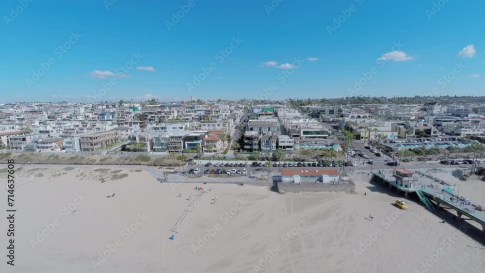 People walk by Manhattan Beach with long pier at autumn sunny day People walk by Manhattan Beach with long pier at autumn sunny day
