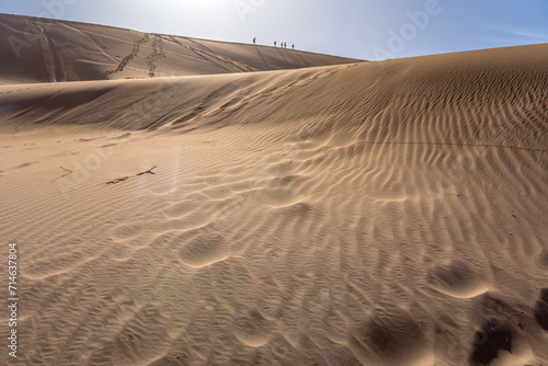 Fototapeta Naklejka Na Ścianę i Meble -  tracks on sand of dune slope and climbers on dune edge , Naukluft desert, Deadlvei,  Namibia