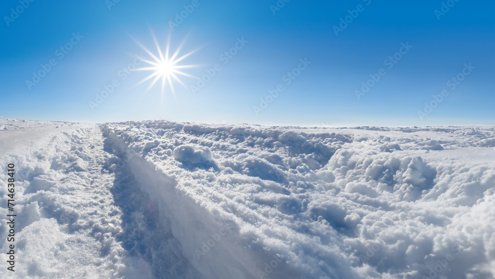 Winter landscape with snow, blue sky and sun star