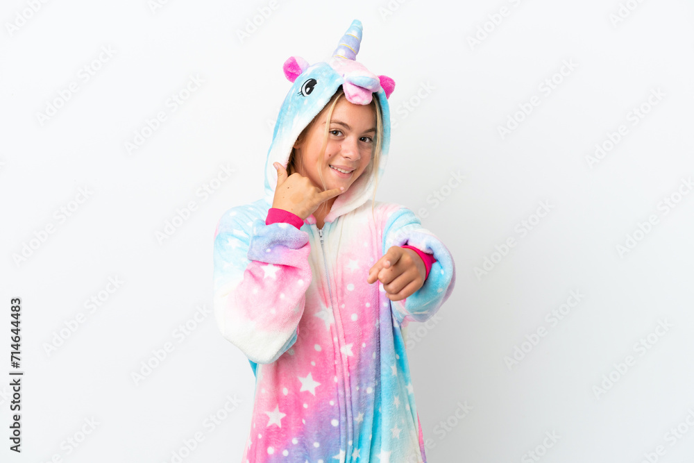 Little girl with unicorn pajamas isolated on white background making phone gesture and pointing front Little girl with unicorn pajamas isolated on white background making phone gesture and pointing front