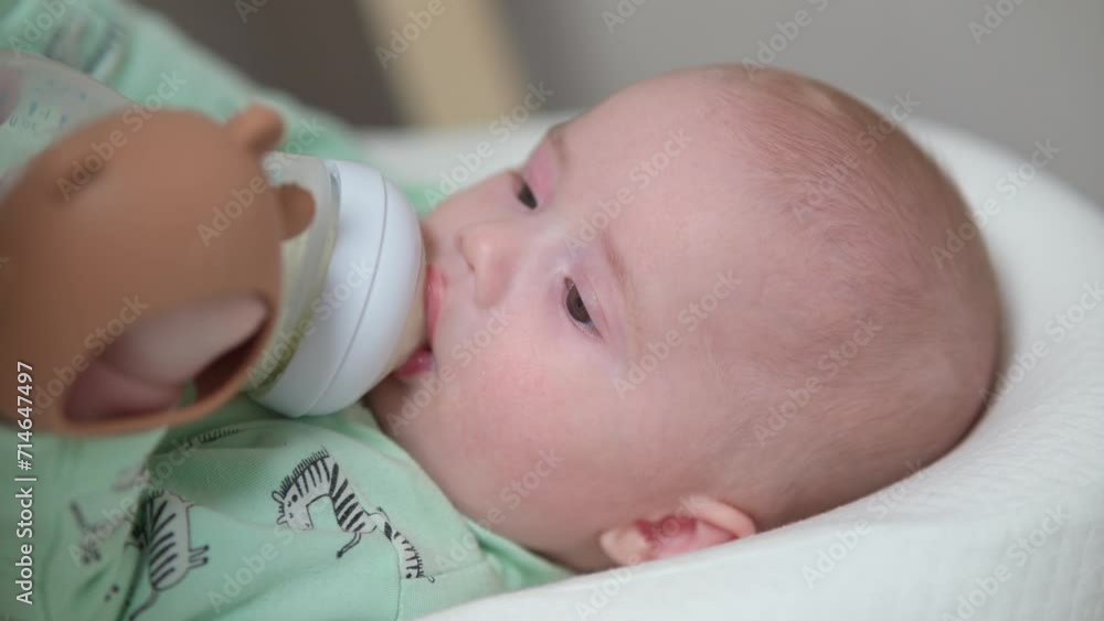 Loving mother feeding her little boy child with milk baby bottle at home, portrait infant Baby eating, drinking powdered milk. Loving mother feeding her little boy child with milk baby bottle at home, portrait infant Baby eating, drinking powdered milk.