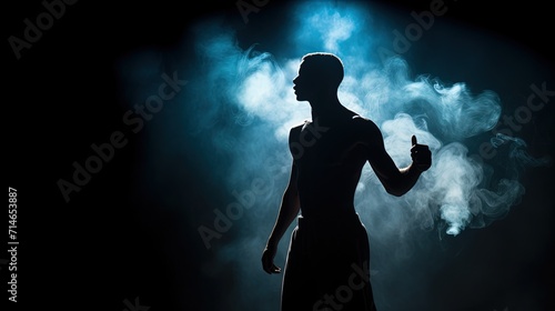 Silhouette of a muscular athlete standing in a spotlight surrounded by dramatic mist, evoking a sense of strength and determination. 