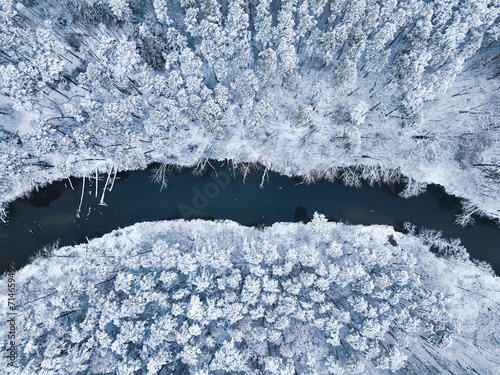 Top down view of Brda river and snowy forest.