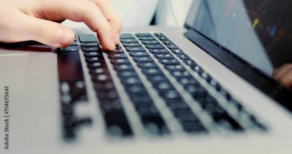 Close-up on laptop keyboard with backlit keys, boy's fingers press on keyboard while playing game. Close-up on laptop keyboard with backlit keys, boy's fingers press on keyboard while playing game.