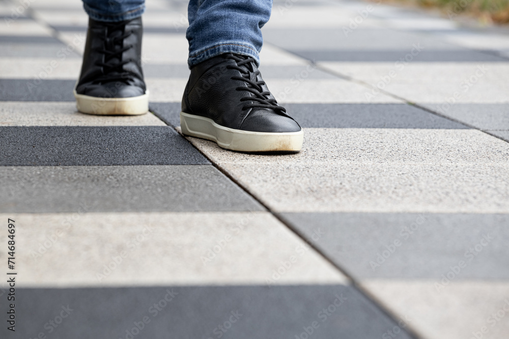 a man walks along a stone tile path. a man walks along a stone tile path.