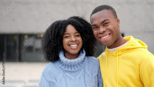 African young couple smiling at camera standing in the street photo