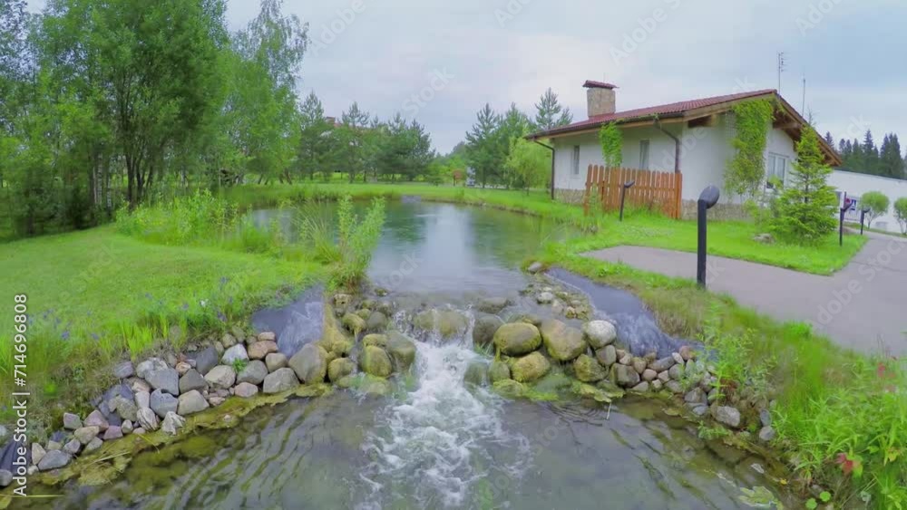 Water flows from small pond near country house at summer Water flows from small pond near country house at summer
