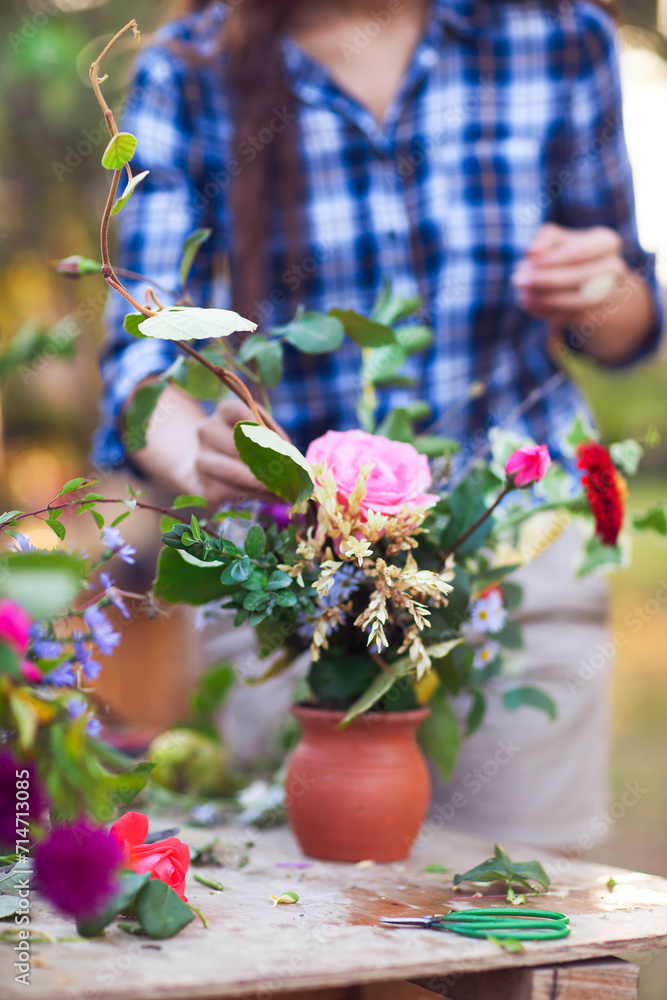 Woman florist making bouquet outdoors. Close up