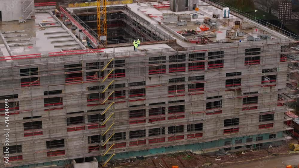 Aerial shot of construction site. Technicians in reflective jackets discussing on top of structure. Frankfurt am Main, Germany