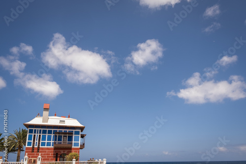 Seascape. The Chinese house in the village of Arrieta in Lanzarote. Blue and red house. Famous building. Blue sky with clouds. Landscape. Canary Islands, Spain photo