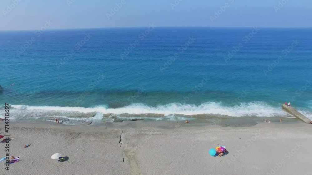 Sea beach with several people at summer sunny day. Aerial view