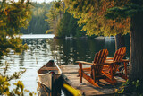 On a wooden dock by a lake in Muskoka, Ontario, Canada, two Adirondack chairs invite relaxation, while a red canoe is securely tethered to the pier