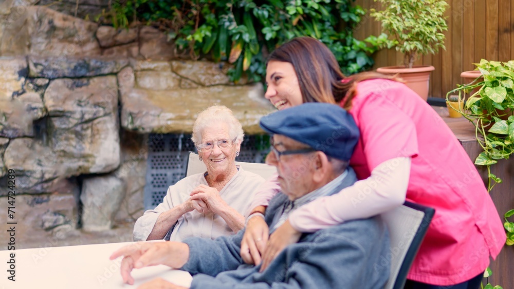 Fototapeta premium Nurse and seniors talking and laughing in a geriatric