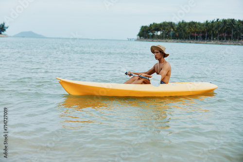 Fun-filled Kayaking Adventure on a Tropical Beach: Active Asian Man Enjoying Summer Vacation