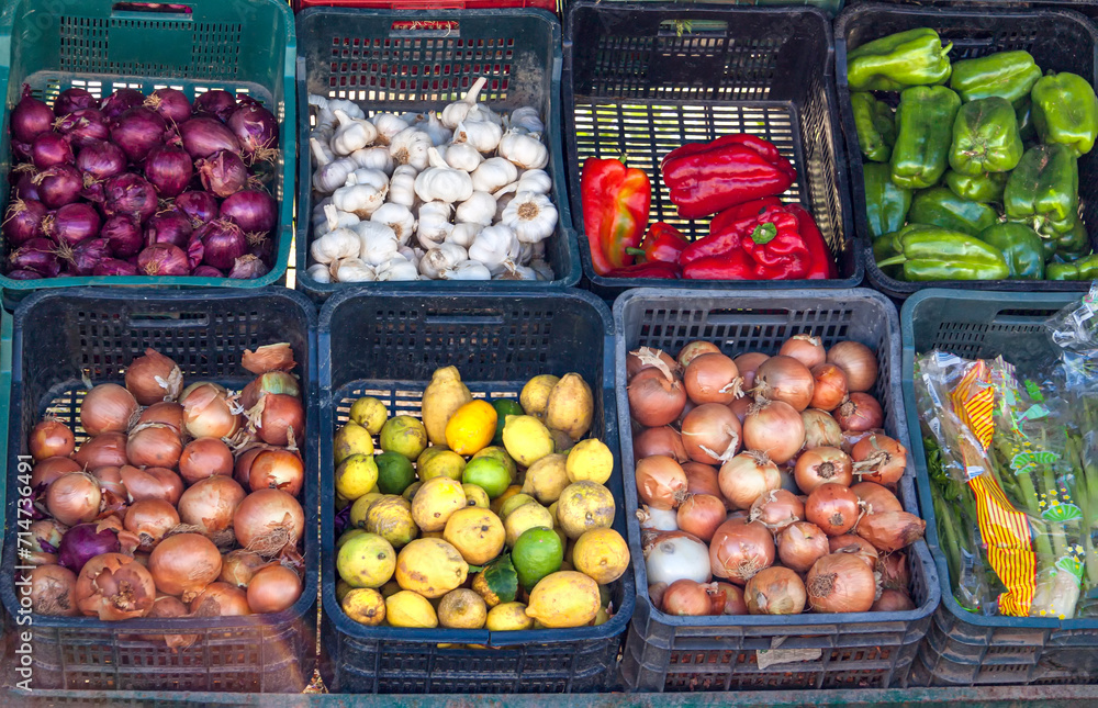 cestos con pimientos rojos, pimientos verdes, cebolla, cebolla morada, limones y ajos a la venta en el supermercado o en el mercado.