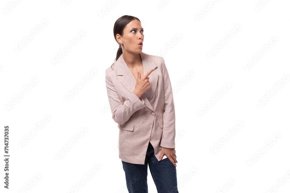 young surprised brunette with a smooth hairstyle dressed in a light jacket looks thoughtfully on a white background with copy space young surprised brunette with a smooth hairstyle dressed in a light jacket looks thoughtfully on a white background with copy space
