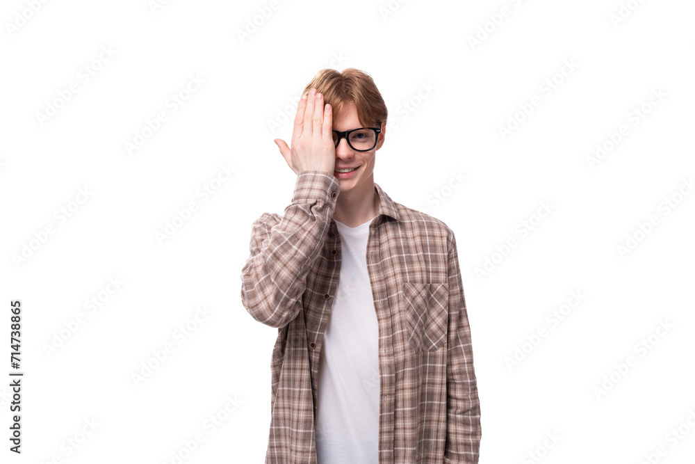 young european man with golden red hair wears glasses and a shirt over a t-shirt young european man with golden red hair wears glasses and a shirt over a t-shirt