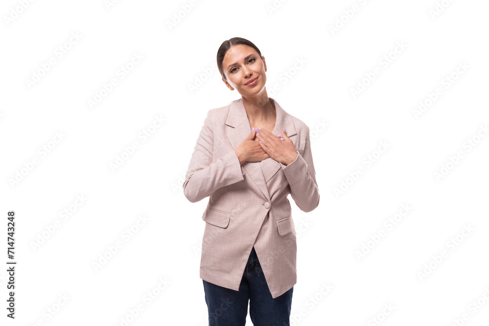 young stylish brunette woman dressed in a beige jacket and jeans on a white background young stylish brunette woman dressed in a beige jacket and jeans on a white background