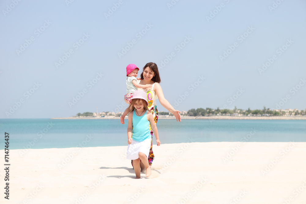 Mother and her two little daughters on the beach