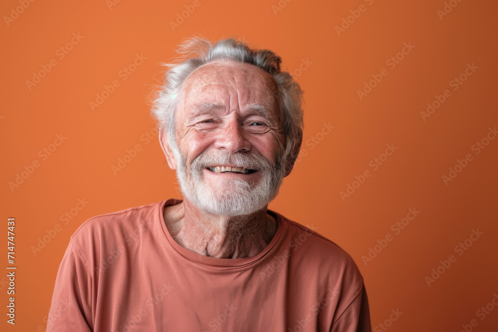 An older man with a beard is smiling for the camera An older man with a beard is smiling for the camera