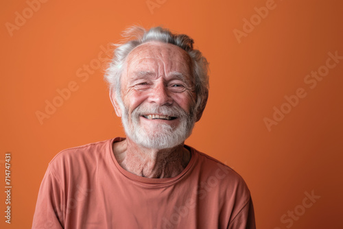 An older man with a beard is smiling for the camera