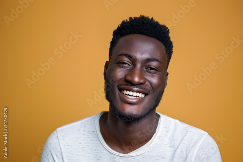 A man with a beard is smiling and wearing a white shirt