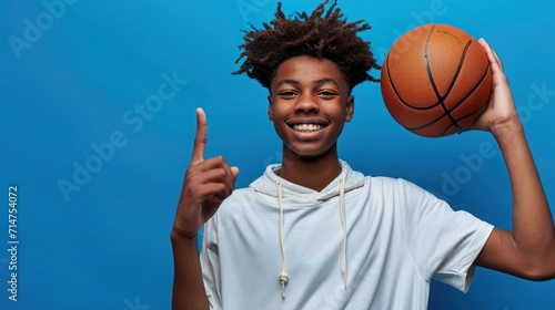 Teenage basketball player against blue wall. © Irina