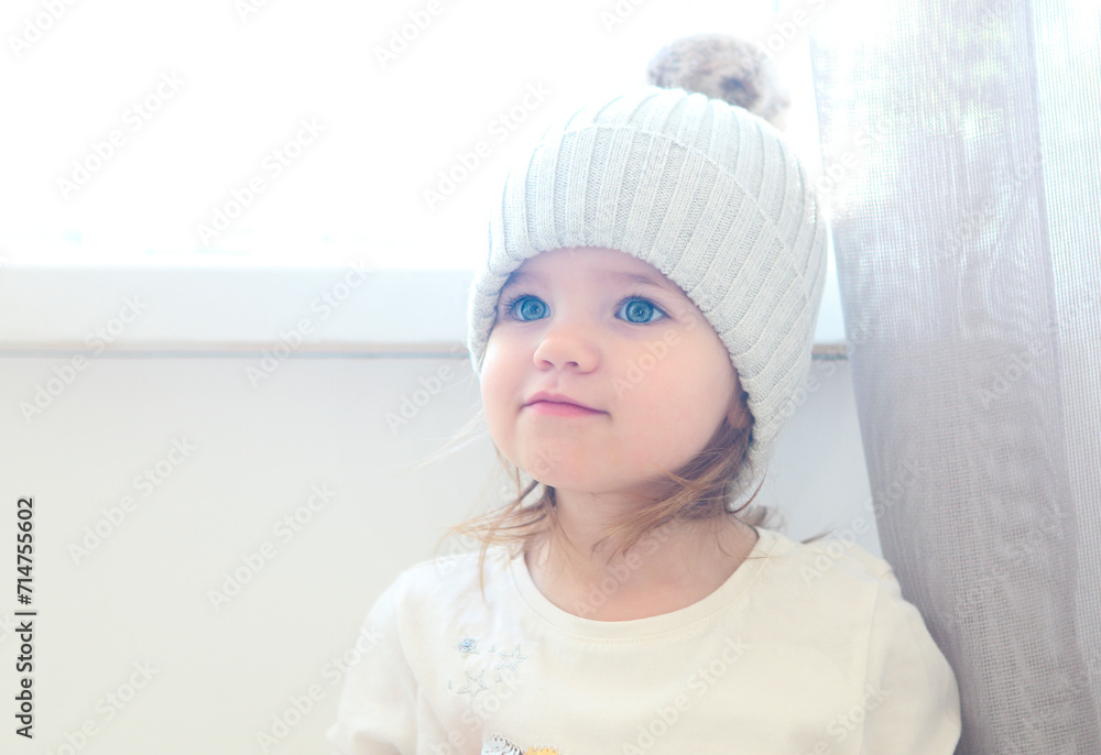 Cute smiling toddler girl looking away isolated on white