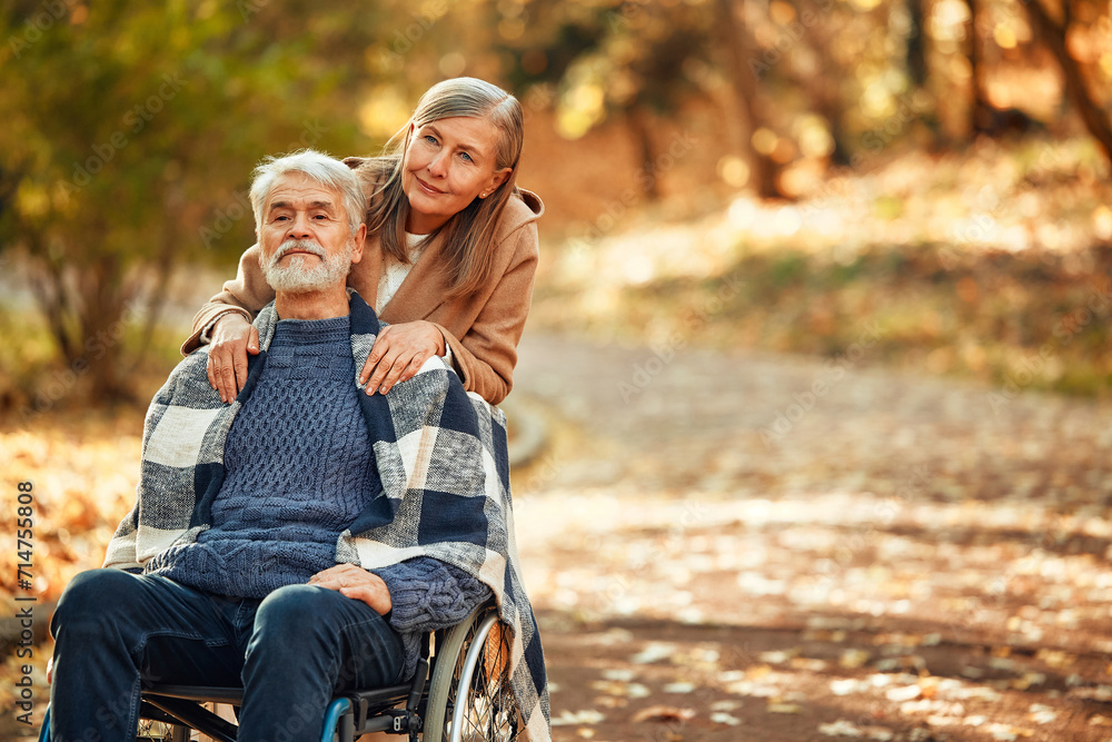 Senior couple walking in the park in autumn Senior couple walking in the park in autumn