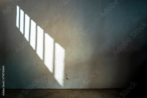 DARK CELL IN JAIL OR PRISON WITH SUNLIGHT THROUGH THE BARRED WINDOW. PRISONER SERVING SENTENCE. photo