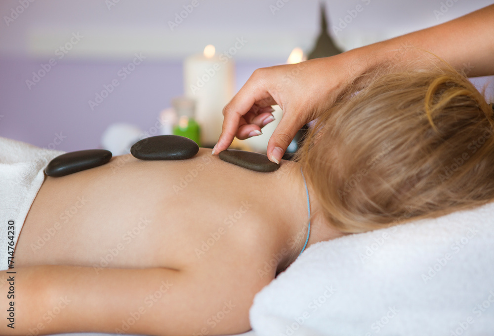 Fototapeta premium Little girl back receiving hot stone massage