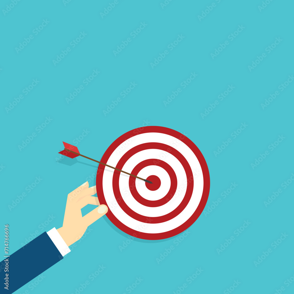 Hand holding a target, showing a goal. Red arrow hits the center. Business challenge failure and success concept. Hand holding a target, showing a goal. Red arrow hits the center. Business challenge failure and success concept.
