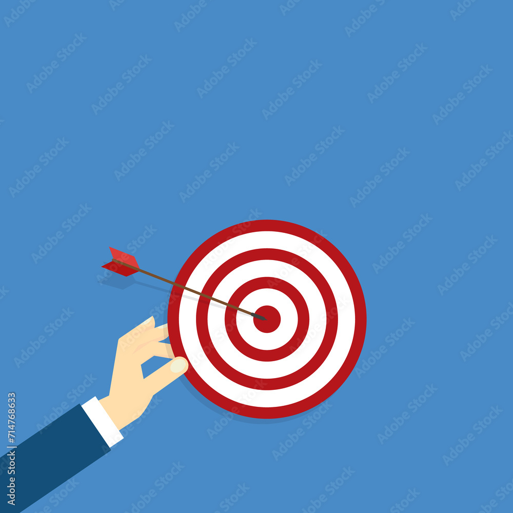 Hand holding a target, showing a goal. Red arrow hits the center. Business challenge failure and success concept. Hand holding a target, showing a goal. Red arrow hits the center. Business challenge failure and success concept.