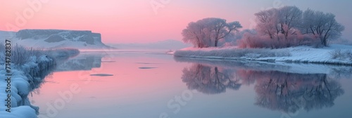 Iced lake in the early morning, the surface reflecting the pastel hues of the sunrise and surrounding landscape