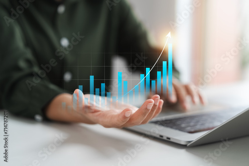 Businesswoman analyzing company's business financial balance sheet working with digital augmented reality graphics, Businesswoman calculates financial data for long-term investment. photo