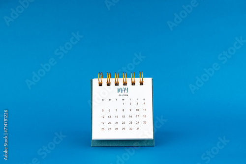 May 2024 mini desk calendar on blue.