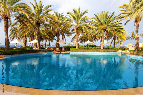 Swimming pool with clear water surrounded by palm trees in one of the best resorts © ArtEvent ET