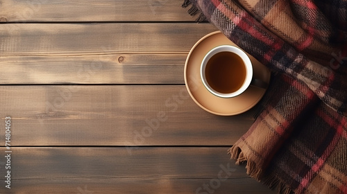flat lay composition with tea and warm plaid on wooden table