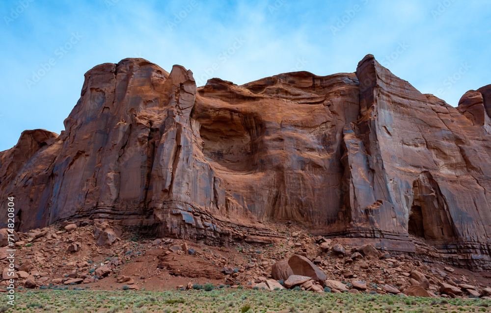 Desert landscape with red rocks and dry vegetation on red sands in Monument Valley, Navajo Nation,  Arizona - Utah
