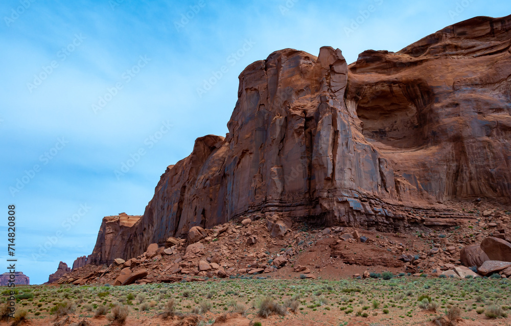 Desert landscape with red rocks and dry vegetation on red sands in Monument Valley, Navajo Nation,  Arizona - Utah