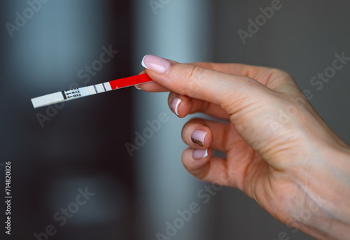 Woman hand holding positive pregnancy test with two lines on it. Pregnancy or fertility concept. High quality photo. photo