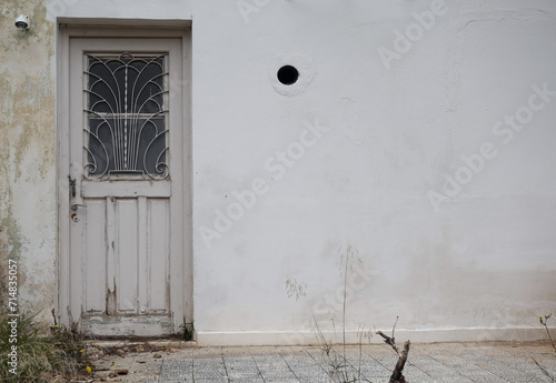 old door with vintage iron grille doorlight design and textured wall abandoned house exterior