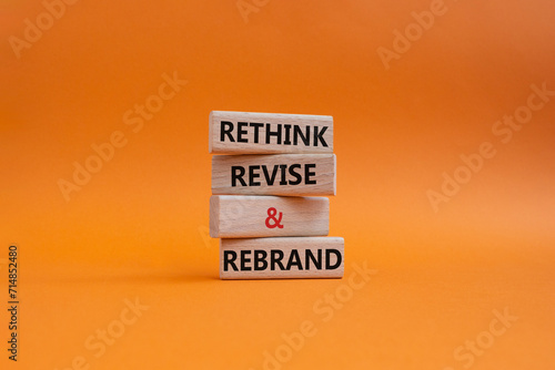 Rethink Revise and Rebrand symbol. Wooden blocks with words Rethink Revise and Rebrand. Beautiful orange background. Business and Rethink Revise and Rebrand concept. Copy space. photo