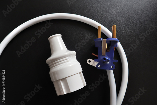 Close up view of disassembled electrical plug on black background