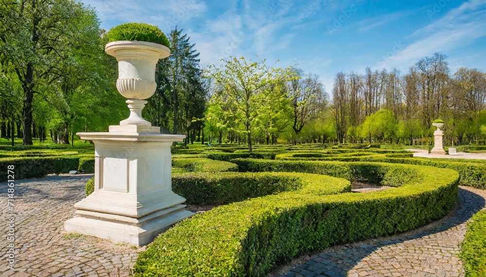 green buxus labyrinths and decorative greek urn in spring park
