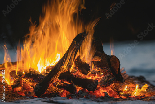 The hearth burns beautifully. Burning wood and hot flames, on a dark background, close-up. A big bonfire made of boards. Firewood in a bright flame