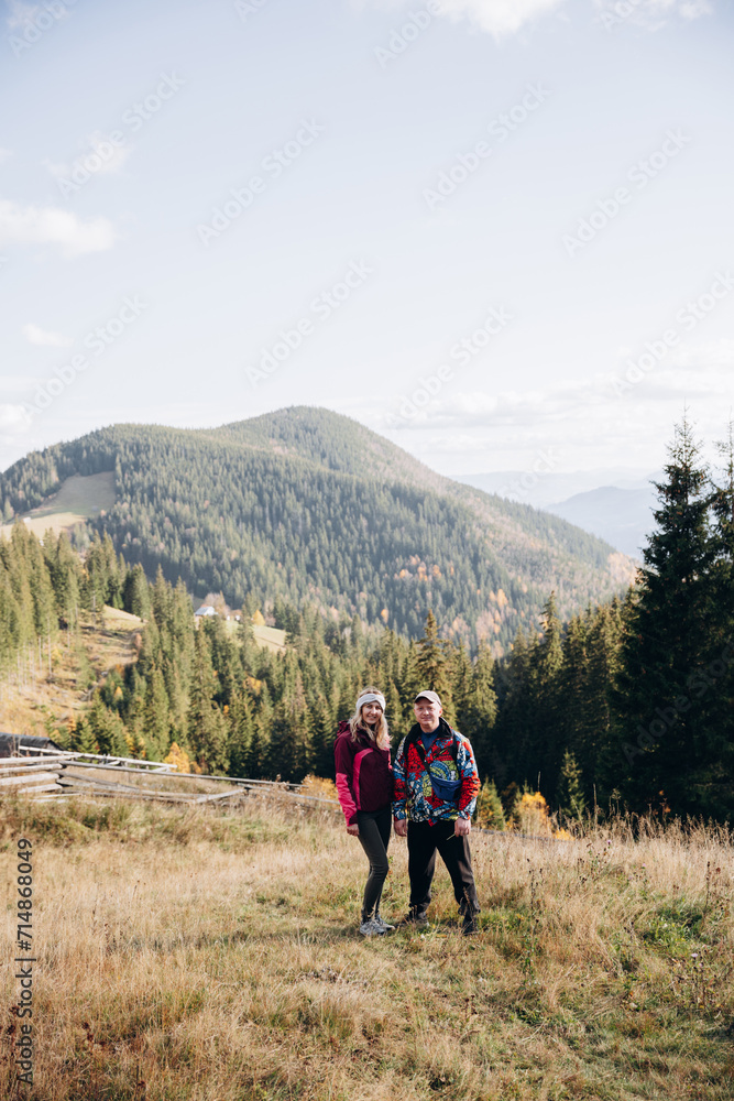family young couple in the mountains, autumn forest. a man and a woman went to the mountains. clothes and shoes for trekking. Man and a woman went on a mountain trip. CARPATHIAN MOUNTAINS
