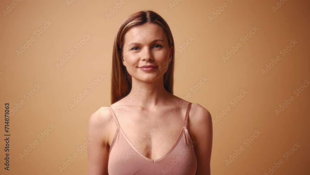 Beautiful young slender caucasian woman in beige lingerie posing on beige background. The concept of skin care, cosmetology and spa treatments. Beautiful young slender caucasian woman in beige lingerie posing on beige background. The concept of skin care, cosmetology and spa treatments.